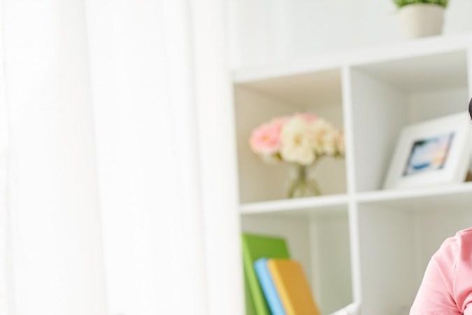 Mujer afroamericana embarazada feliz con papeles y calculadora contando dinero en casa.