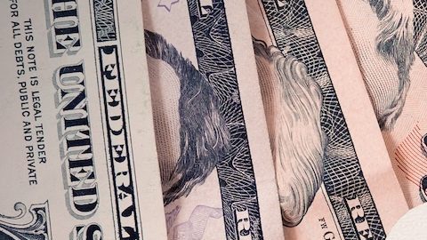 Familia de papel recortado con billetes de dólares en primer plano.