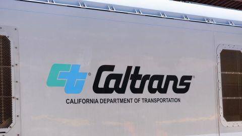 Logotipo de Caltrans y letrero del Departamento de Transporte de California en una locomotora diésel de pasajeros.