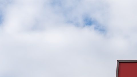 Un cartel en un poste de un restaurante Wendy's con un cielo azul de fondo.