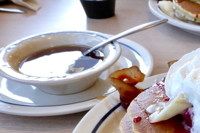 Panqueques IHOP con tocino, jarabe de arce y plátano y crema.