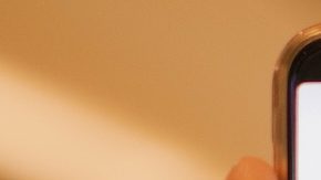 Mano sosteniendo un teléfono inteligente que muestra la aplicación Target con un centro comercial de fondo.