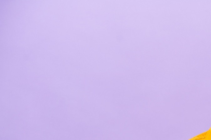 Joven caucásico sosteniendo comida rápida aislada sobre fondo morado estrechando la mano para cerrar un buen trato.