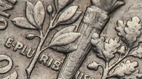 Antorcha, rama de roble y rama de olivo representadas en la moneda de diez centavos de Estados Unidos.