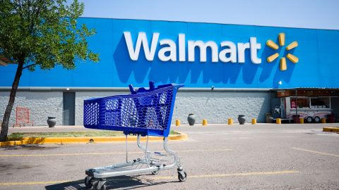 Carrito de compras en un estacionamiento frente a la entrada principal del supermercado Walmart.