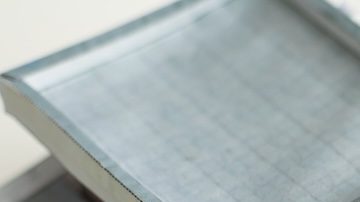 Casa miniatura sobre billetes de $100 dólares.