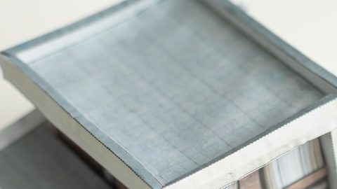Casa miniatura sobre billetes de $100 dólares.