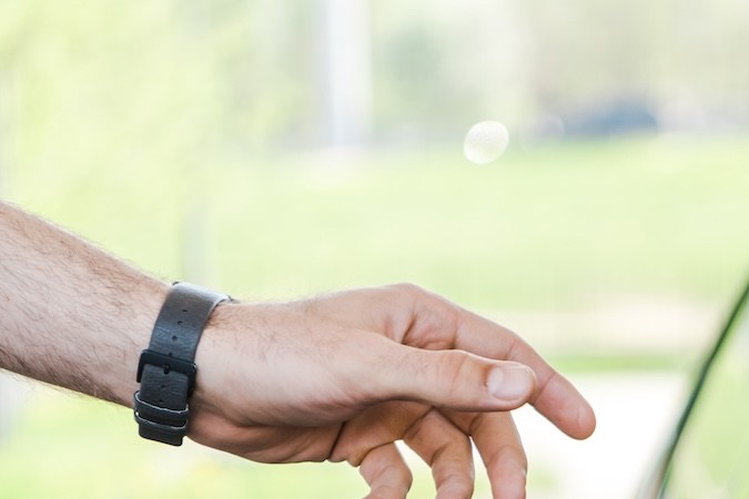 Vista recortada de una mujer en un automóvil que le da una tarjeta de crédito a un trabajador en una gasolinera.