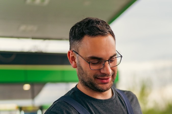 Una joven paga combustible en una gasolinera con una tarjeta, el trabajador le entregó una terminal para pagar.