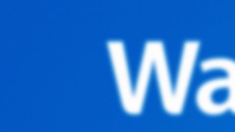 El logotipo de Walmart Plus se muestra en la pantalla del teléfono inteligente con el logotipo de Walmart en el fondo.