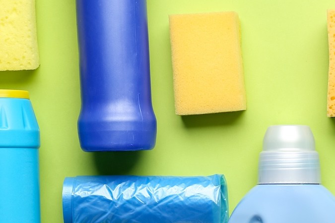 Muchos productos de limpieza diferentes sobre fondo verde.