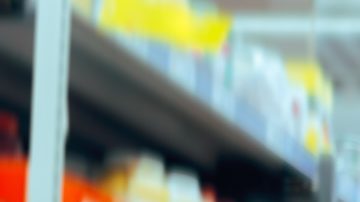 Mujer abrumada en un pasillo del supermercado.