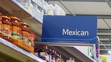 Clientes recorren un pasillo de un supermercado.