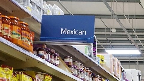 Clientes recorren un pasillo de un supermercado.