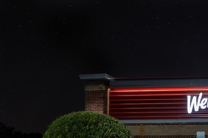 Restaurante Wendy's en Fort Mill, Carolina del Sur, cerrado e iluminado con las estrellas arriba.