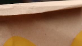 Mujer con menú de McDonald's en una mesa de madera al aire libre, primer plano.