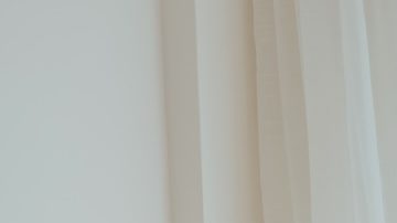 Mujer joven aspirando el piso en una habitación acogedora y luminosa con una aspiradora inalámbrica.