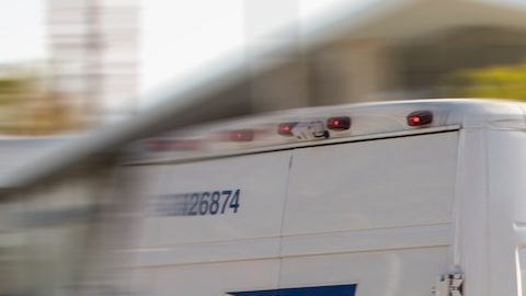 Un camión de correo de USPS sale para realizar una entrega.