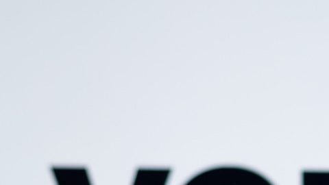 En esta ilustración fotográfica, la silueta de una mujer sostiene un teléfono inteligente con el logotipo de Verizon Communications de fondo.