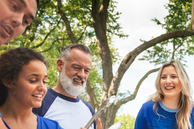 Amigas bebiendo y comiendo en una fiesta en el portón trasero.