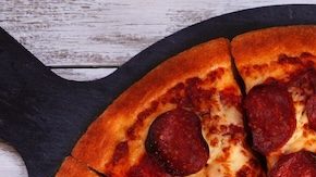 Mesa de comida con temática de fútbol o Super Bowl. Pizza, hamburguesas, alitas, bocadillos y guarniciones.