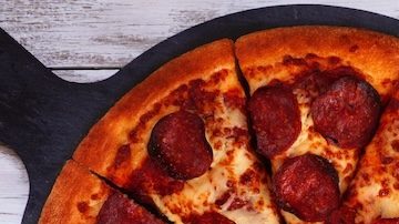 Mesa de comida con temática de fútbol o Super Bowl. Pizza, hamburguesas, alitas, bocadillos y guarniciones.