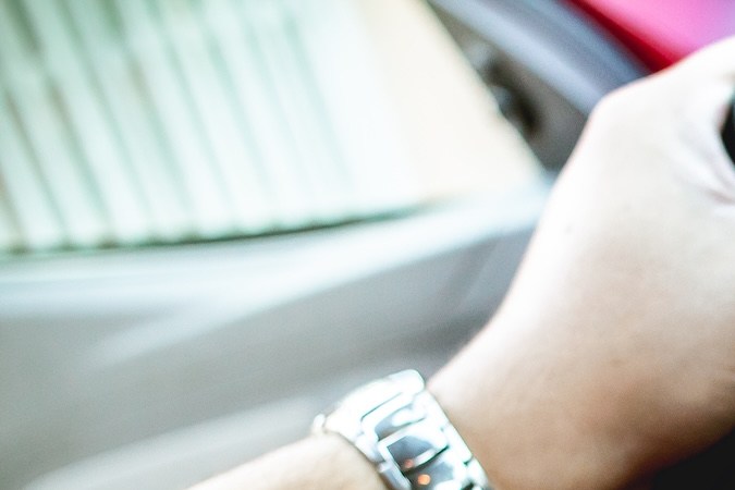 Fotografía de un hombre dentro de un automóvil Chevrolet Agile modelo 2014, sosteniendo el volante.