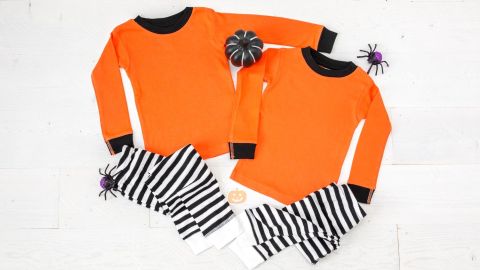 Dos pijamas de Halloween para niños pequeños de color naranja en blanco sobre fondo blanco, maqueta de pijama de Halloween para hermanos.
