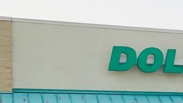 Un carrito lleno de productos frente a una tienda de descuentos Dollar Tree.