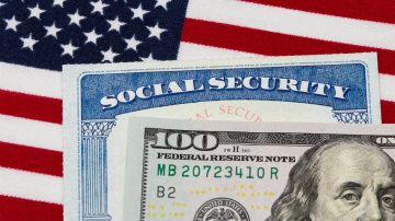 Tarjeta de seguridad social, billete de 100 dólares y bandera estadounidense. Concepto de pago de prestaciones de seguridad social, jubilación y prestaciones del gobierno federal.