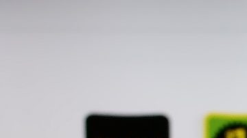 Persona que sostiene un teléfono móvil con el logotipo de la empresa minorista estadounidense Dollar General Corporation en la pantalla frente a una página web.