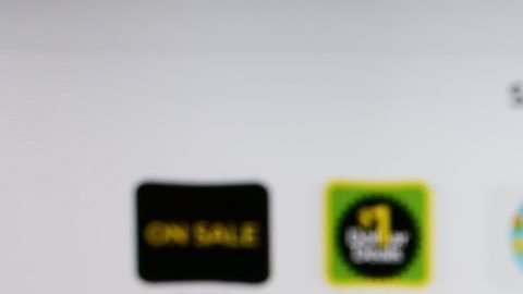 Persona que sostiene un teléfono móvil con el logotipo de la empresa minorista estadounidense Dollar General Corporation en la pantalla frente a una página web.