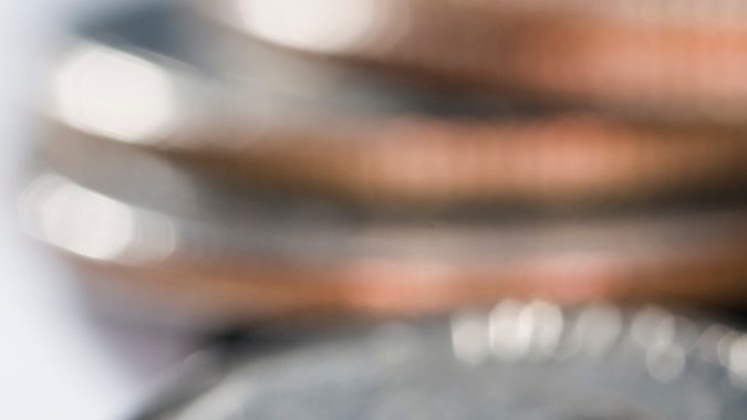 Una vista de cerca de varias monedas estadounidenses, incluida una de cinco centavos con la imagen de Jefferson, con monedas de un centavo y de diez centavos apiladas cerca.