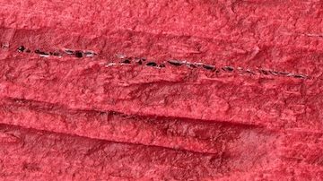 Vista posterior de una antigua moneda de medio dólar de plata de Franklin sobre un fondo rojo.