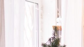 Interior de la sala de estar de estilo escandinavo, decorada para las fiestas navideñas. Árbol de Navidad junto a la chimenea.