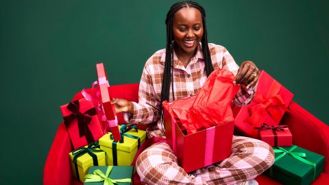 Mujer abre regalos feliz, tras sus compras del Black Friday en Walmart.