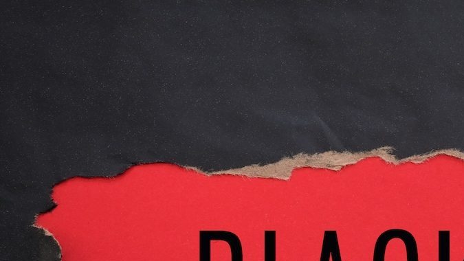 Papel rasgado de color negro y texto Black Friday sobre un fondo rojo.