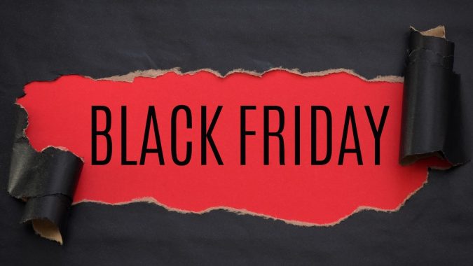 Papel rasgado de color negro y texto Black Friday sobre un fondo rojo.