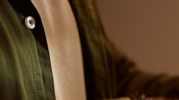 Primer plano de un hombre cortando un pavo asado durante la cena de Acción de Gracias en el comedor.