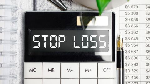Calculadora con texto STOP LOSS en la pantalla y lápiz.