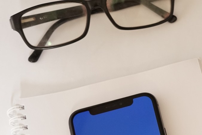 Pantalla de iPhone de Citibank con artículos de papelería y gafas.