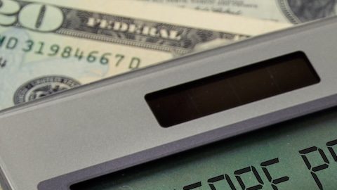 Signo de texto de la Parte B de Medicare en la pantalla de la calculadora con medicamentos recetados en una botella naranja sobre dinero.