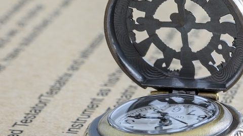 Concepto de legado, herencia o impuesto sobre la muerte como testamento o última voluntad: una pareja de ancianos en miniatura se encuentra de pie sobre un formulario de documento legal y se prepara para transferir propiedades a sus herederos después de la muerte.