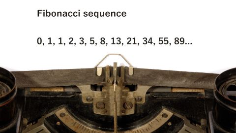 Primer plano de una lista de números de Fibonacci escrita en papel en una máquina de escribir antigua.